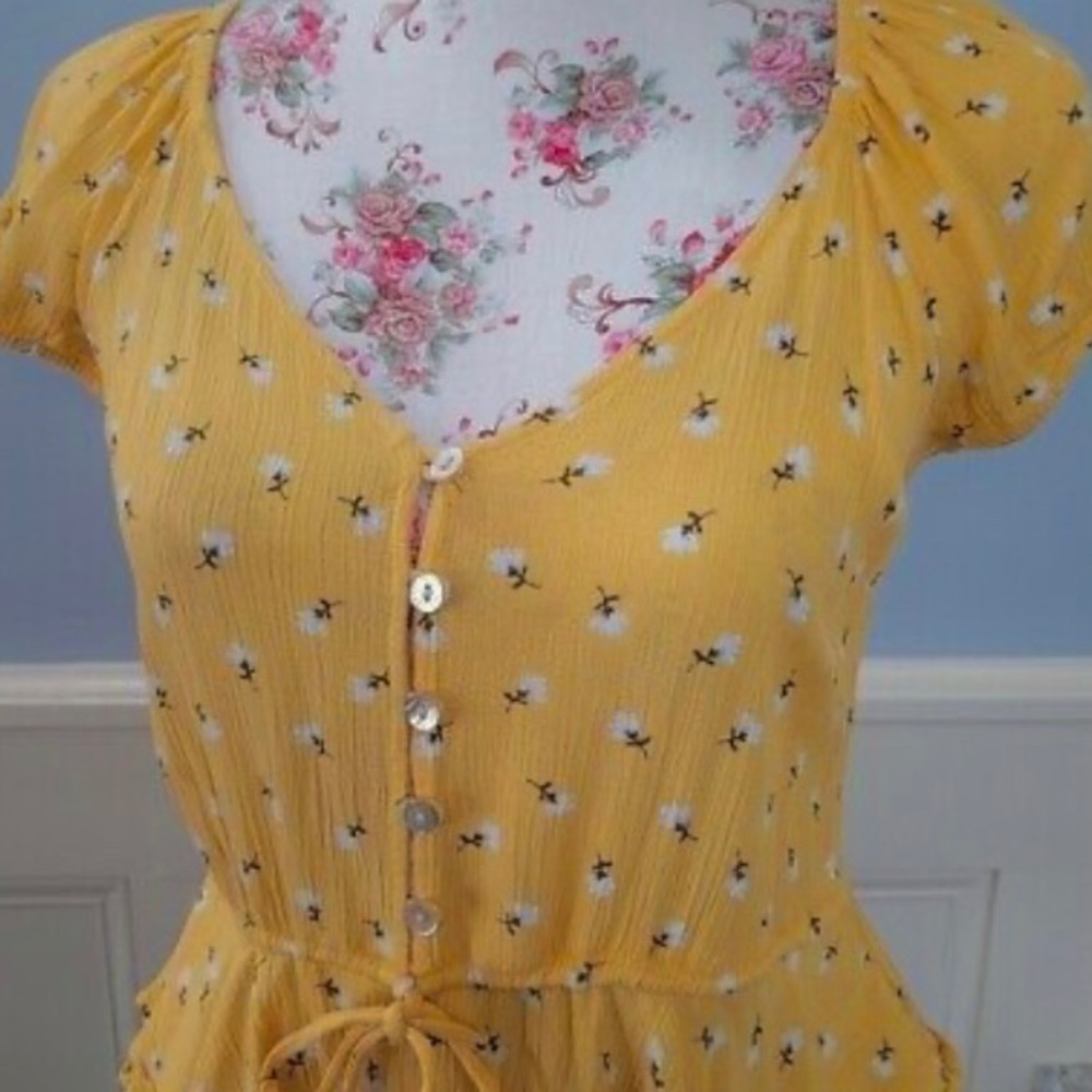 Yellow ruffled blouse with white flowers and buttons
